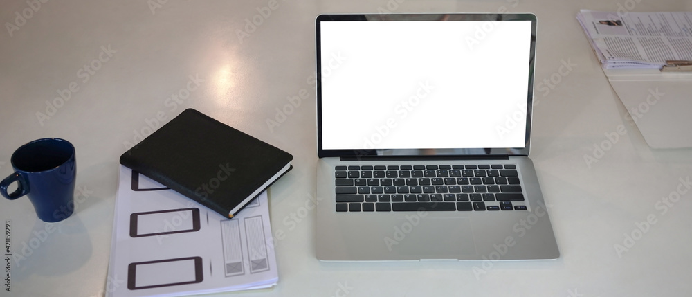 White office desk with laptop computer, notebook, coffee cup and paperwork. White office desk with laptop computer, notebook, coffee cup and paperwork.