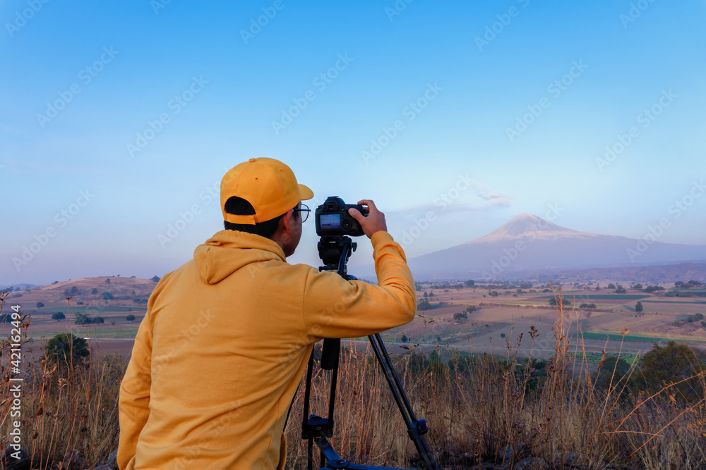 Young Mexican professional photographer with a camera capturing the beautiful landscape