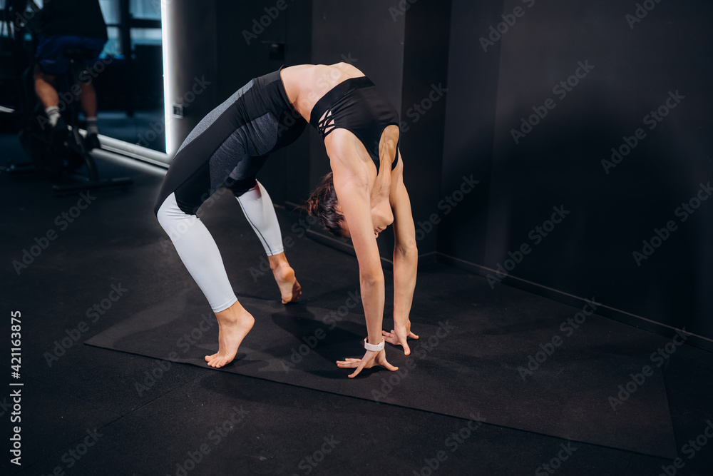 Slim athletic woman doing exercise bridge at gym