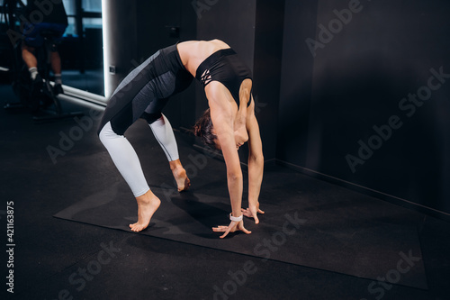 Slim athletic woman doing exercise bridge at gym