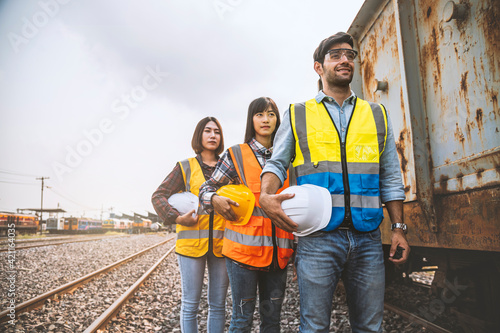 Team engineer holding helmet standing in row on site work at train garage, banner cover design.