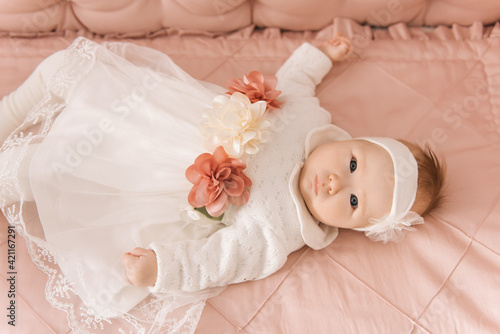Portrait of a cute 6-month-old baby, a newborn girl lying in a baby crib