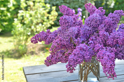 beautiful bouquet of purple lilac on a wooden table in garden