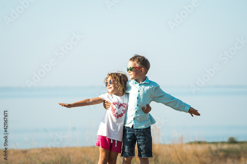 Little girl and boy making windmill. Renewable energies and sustainable resources - wind mills. children playing with the wind near a wind turbine