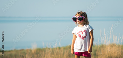 Happy little girl with big sunglasses looking at the sky © shara