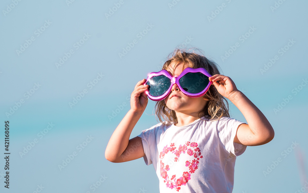 portrait of a little kid girl in big sunglasses. Child on summer sea beach portrait of a little kid girl in big sunglasses. Child on summer sea beach