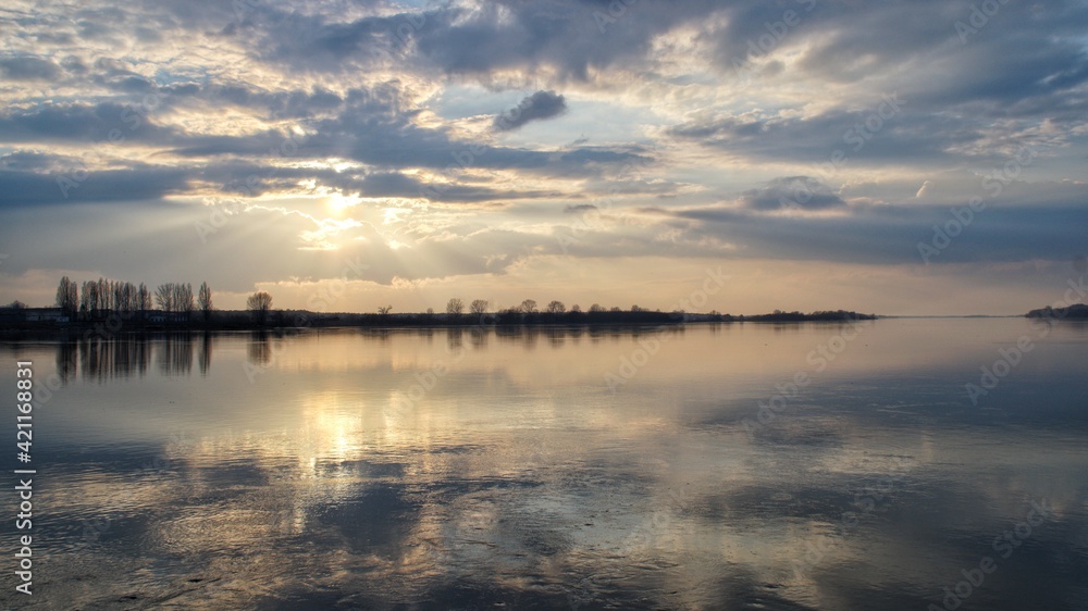 sun and clouds reflecting in the water of the Vistula river in Płock during the sunset