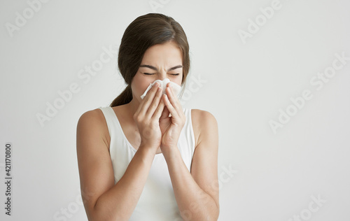 brunette in white t-shirt wipes her face with a handkerchief health problems cold