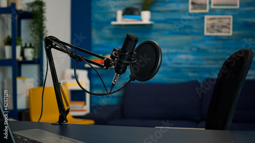 Station for recording and speaking during podcast in night in empty livin room studio. Influencer recording social media content with production microphone, digital web internet streaming station