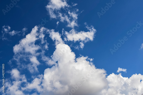 Hazy small cirrostratus  cirrocumulus and cumulus cloud formations on a sunny afternoon in late summer are contrasted against the blue sky.