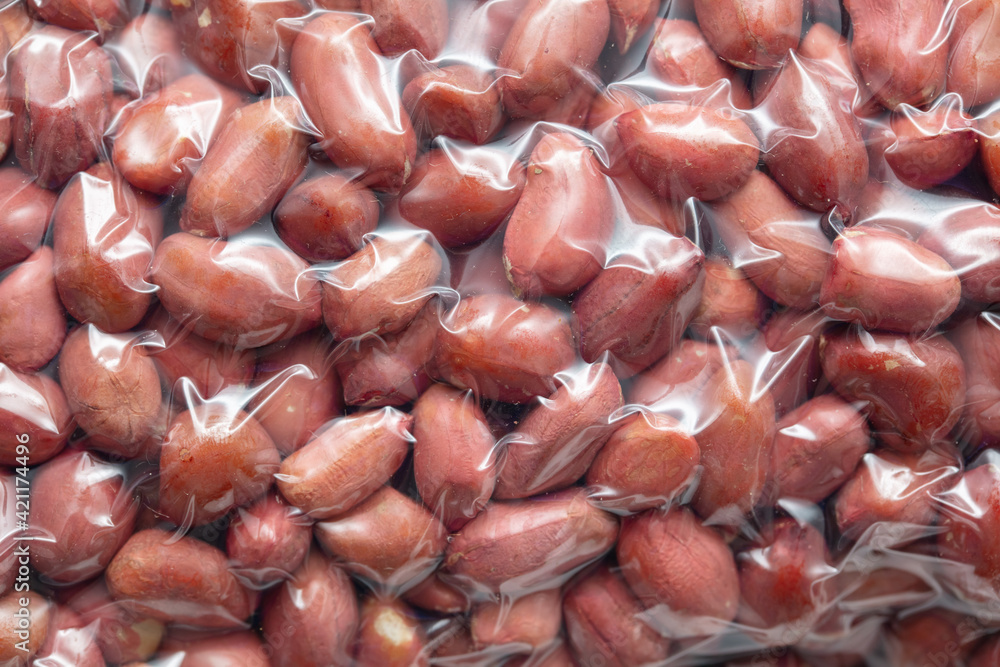Close up of peanut nuts in a plastic bag as a background. Macro