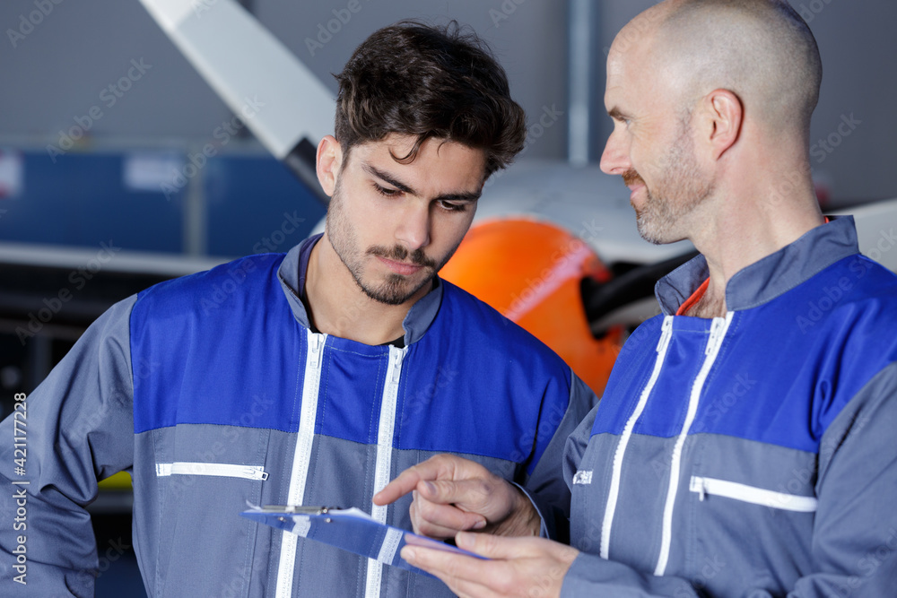 Obraz premium mechanics with clipboard at workshop