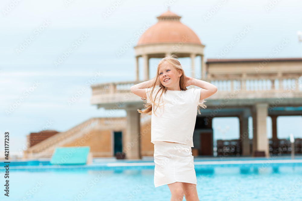 Emotions. Portrait of a happy little girl having fun by the pool. Summer vacation concept