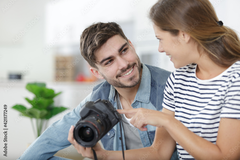 happy couple reviewing photos on camera happy couple reviewing photos on camera