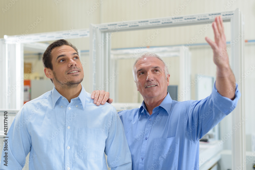 Obraz premium engineer controlling other wokers job in factory