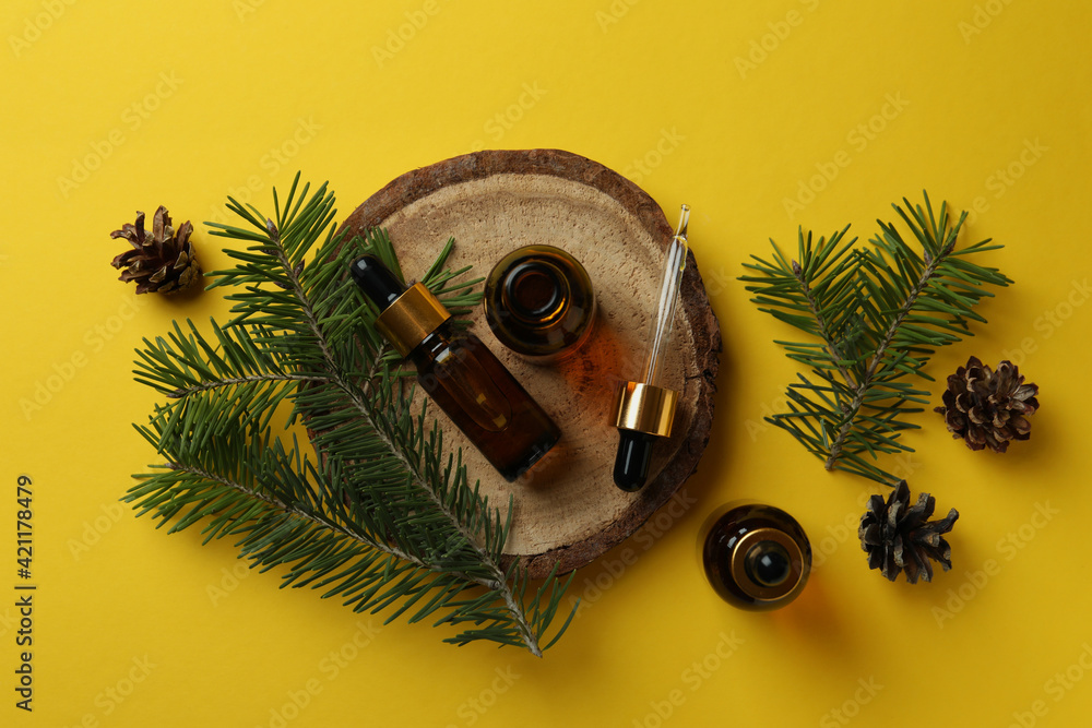 Fototapeta premium Aromatherapy concept with pine oil on yellow background