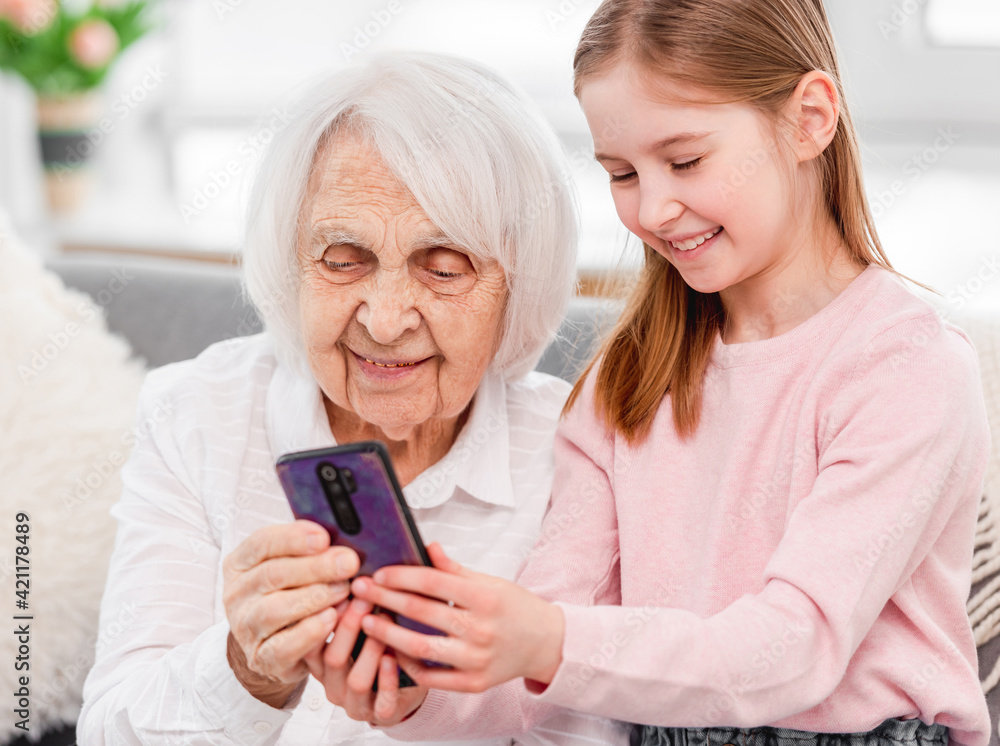 Grandmother with grandaughter using smartphone Grandmother with grandaughter using smartphone