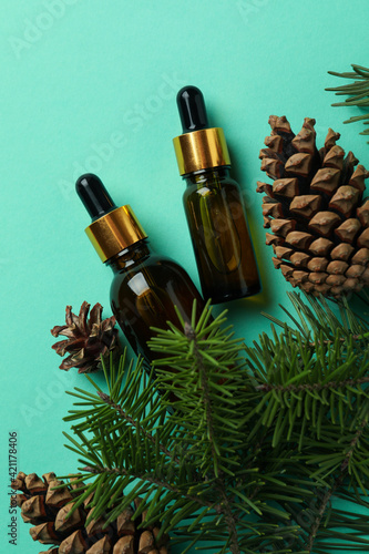 Pine oils, cones and twigs on mint background
