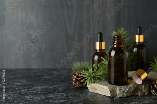 Aromatherapy concept with pine oil on black smoky table