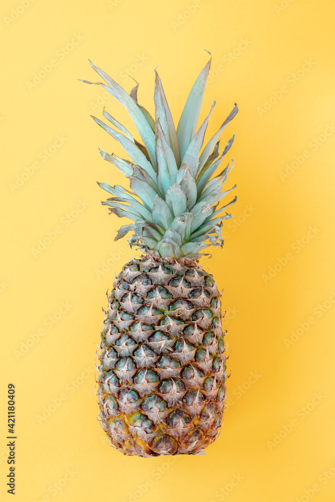 Pineapple on yellow background, top view, flat lay