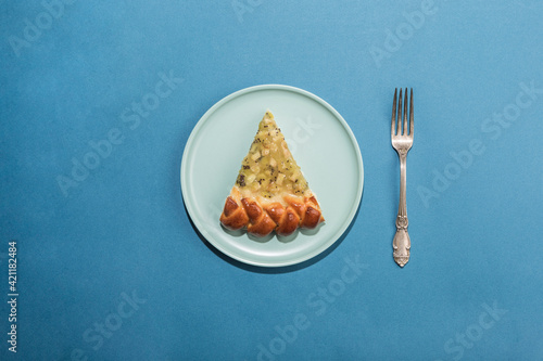 Banana pie on a flat plate with a fork on a blue background. Dessert for a holiday and birthday. Concept.