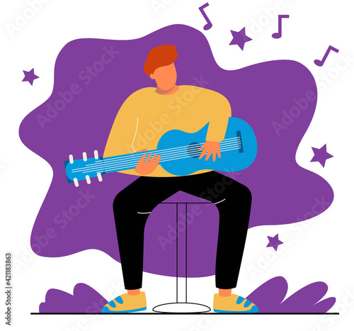 A man plays the guitar. A man sits on a chair and plays the guitar.
