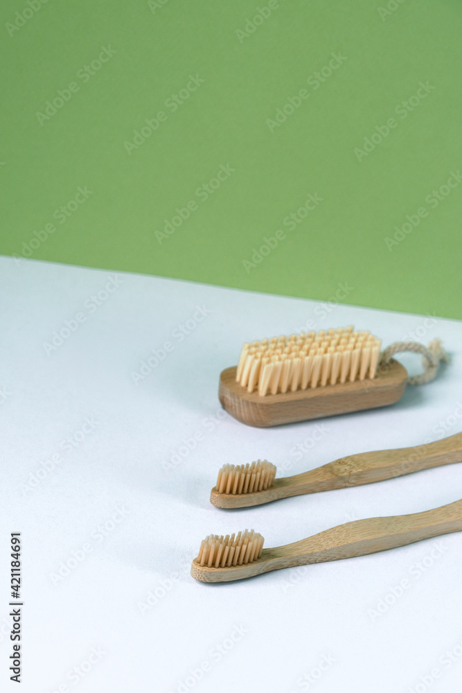 Two toothbrushes and body brush on white and green background. Personal hygiene, zero waste concept Two toothbrushes and body brush on white and green background. Personal hygiene, zero waste concept