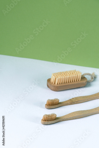 Two toothbrushes and body brush on white and green background. Personal hygiene  zero waste concept