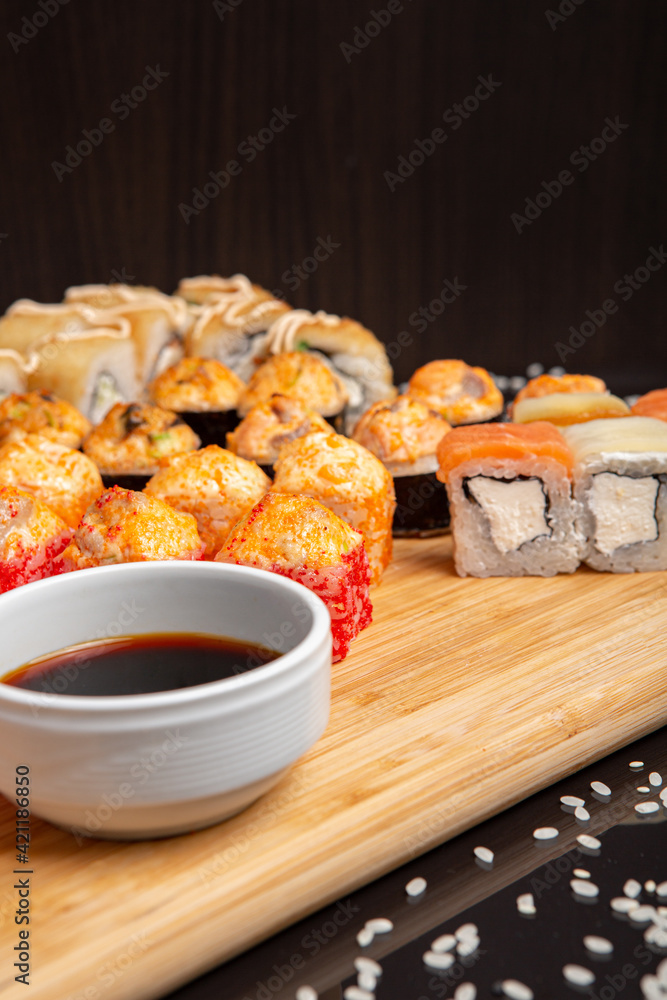 Big sushi set on light wooden dish isolated on black background Big sushi set on light wooden dish isolated on black background