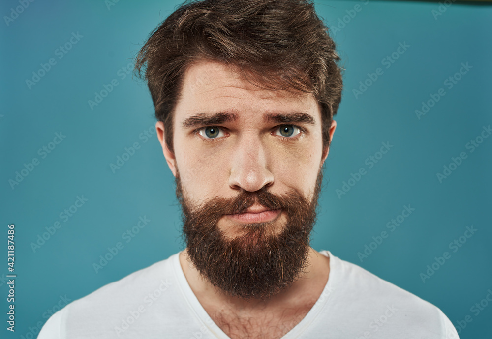 portrait of a sad brunette man on a blue background cropped view portrait of a sad brunette man on a blue background cropped view