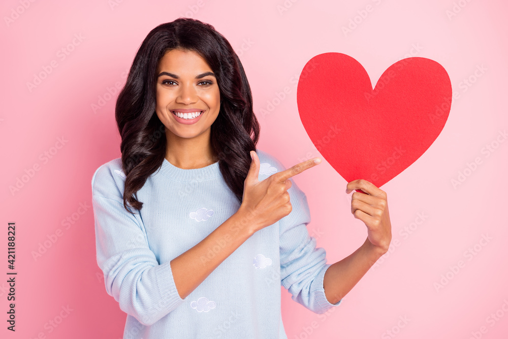 Photo of adviser lady indicate finger red paper heart card wear blue pullover isolated pink background Photo of adviser lady indicate finger red paper heart card wear blue pullover isolated pink background