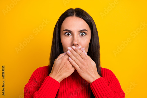 Photo of young shocked amazed surprised woman close mouth hear unbelievable news isolated on yellow color background