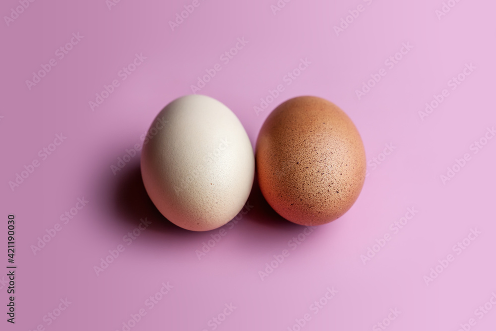 Trendy Fuchsia Pink paired with a rustic egg. A dark and light egg lies on a pink solid background. 
