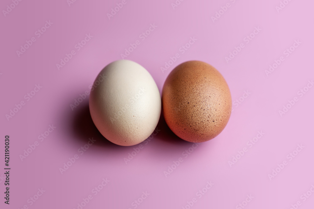 Trendy Fuchsia Pink paired with a rustic egg. A dark and light egg lies on a pink solid background. Trendy Fuchsia Pink paired with a rustic egg. A dark and light egg lies on a pink solid background.