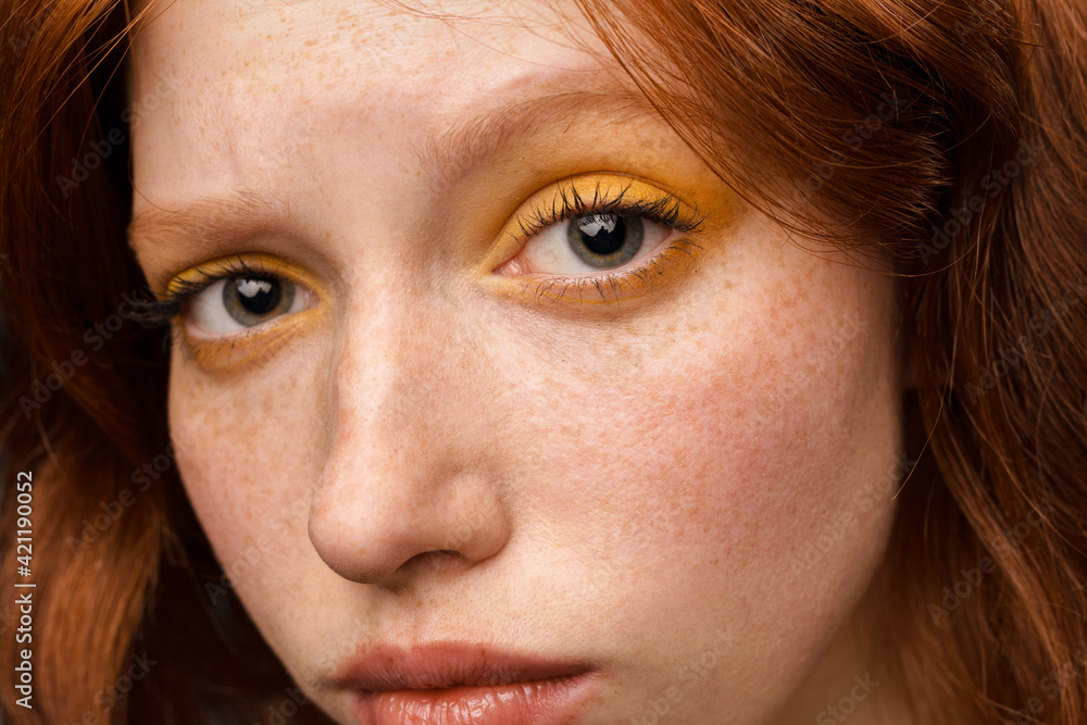 Young ginger white woman with makeup posing and looking at camera Young ginger white woman with makeup posing and looking at camera