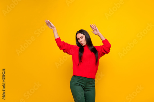 Photo of young beautiful charming woman enjoying dancing wear knitted red sweater isolated on yellow color background