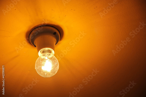 Old light bulb on yellow background