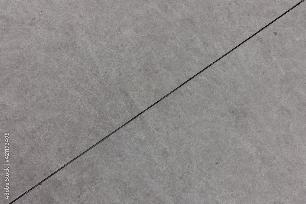 Diagonal joint on grey concrete slab from above