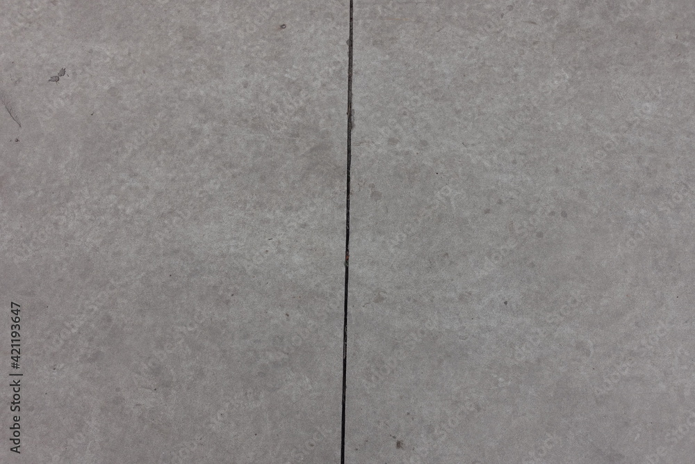Grey concrete slab with joint dividing it in two equal parts