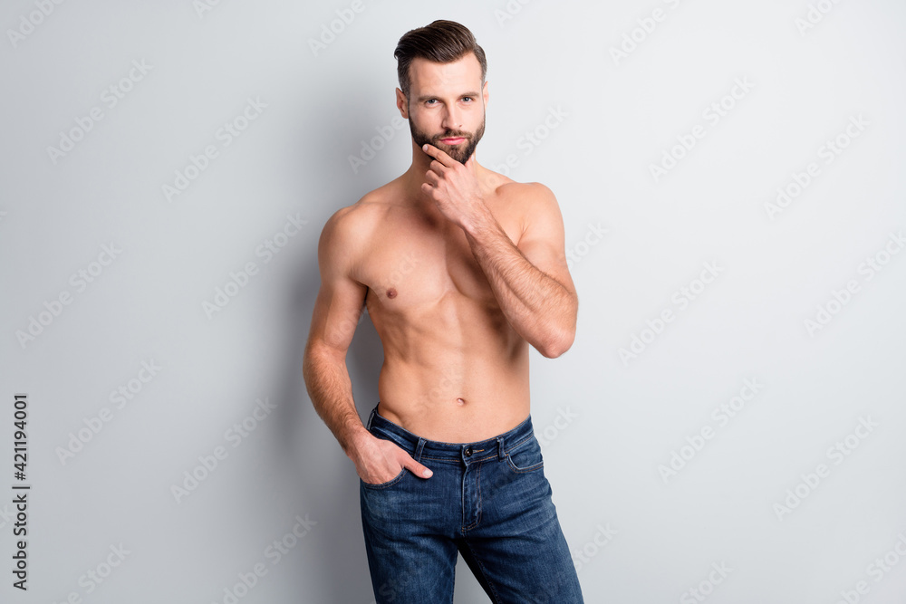 Portrait of attractive content fit guy posing touching chin thinking isolated over light grey color background Portrait of attractive content fit guy posing touching chin thinking isolated over light grey color background