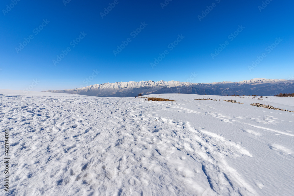 Mountain Range of Monte Baldo and Adamello in winter with snow, view from the Lessinia Plateau (Altopiano della Lessinia) Verona. Veneto and Trentino Alto Adige, Italy, Europe. Mountain Range of Monte Baldo and Adamello in winter with snow, view from the Lessinia Plateau (Altopiano della Lessinia) Verona. Veneto and Trentino Alto Adige, Italy, Europe.