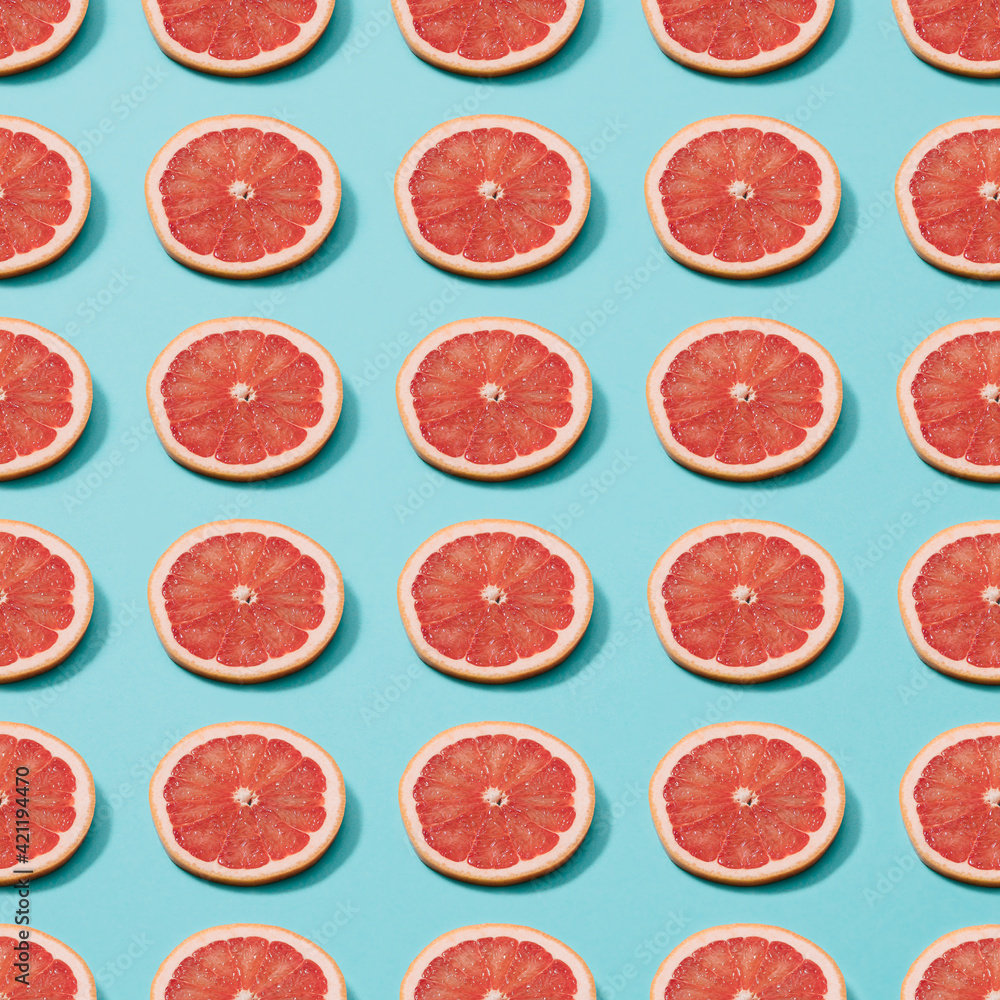 Slices of grapefruit on a blue background. Minimal pattern. Slices of grapefruit on a blue background. Minimal pattern.