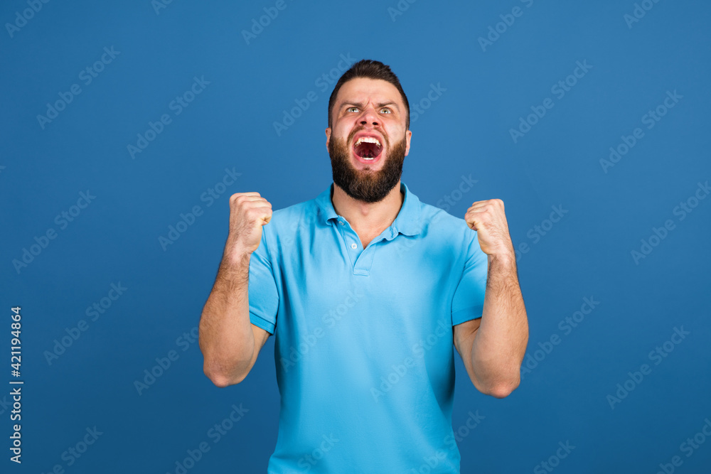 Fototapeta premium Caucasian man's portrait isolated on blue studio background with copyspace