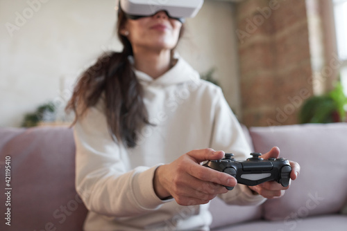 Woman using joystick in game sitting on sofa