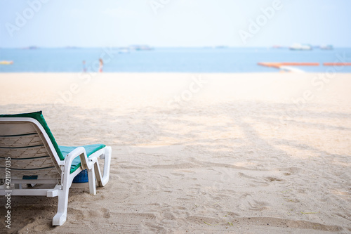 Beach chair or sun bed on sandy beach at coast with blue sea and blue sky blured. for tourist travel summer in holidays.