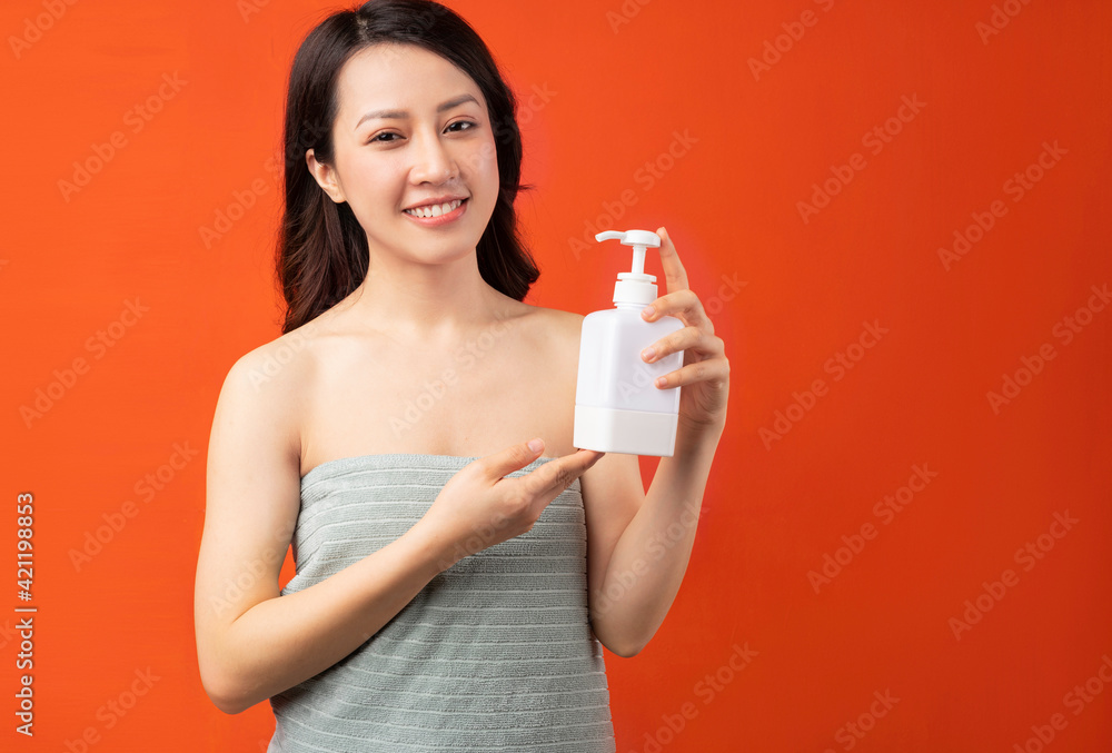 Beautiful young Asian girl taking skin care with a cheerful expression Beautiful young Asian girl taking skin care with a cheerful expression