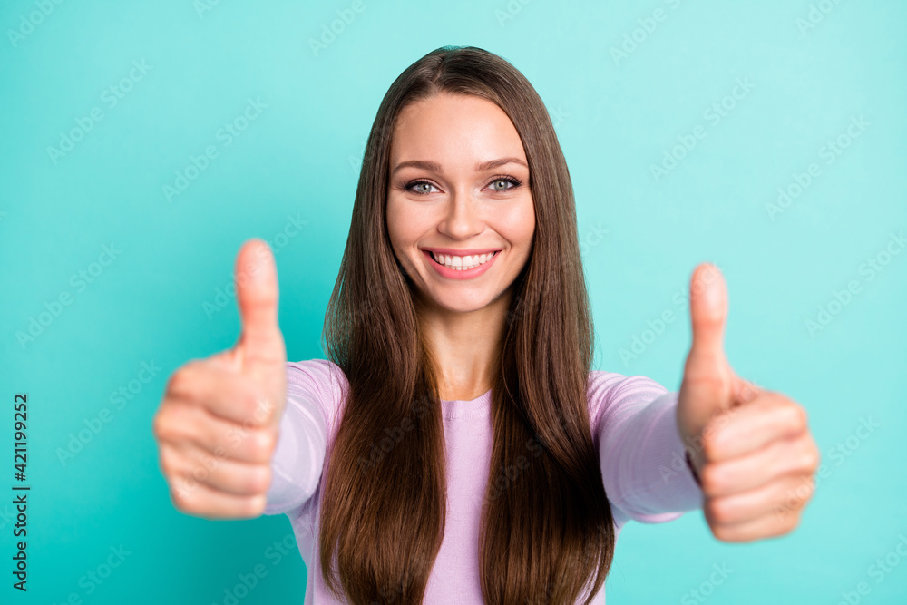 Photo portrait of positive woman showing two thumbs up isolated on vivid turquoise colored background Photo portrait of positive woman showing two thumbs up isolated on vivid turquoise colored background