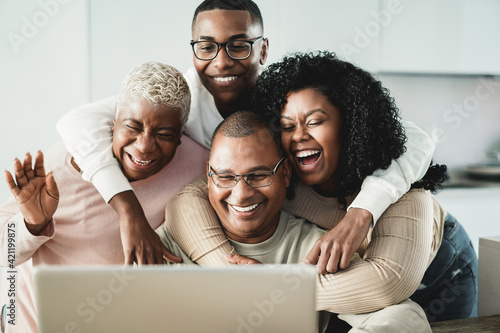 Happy black family doing video call at home - Main focus on father face