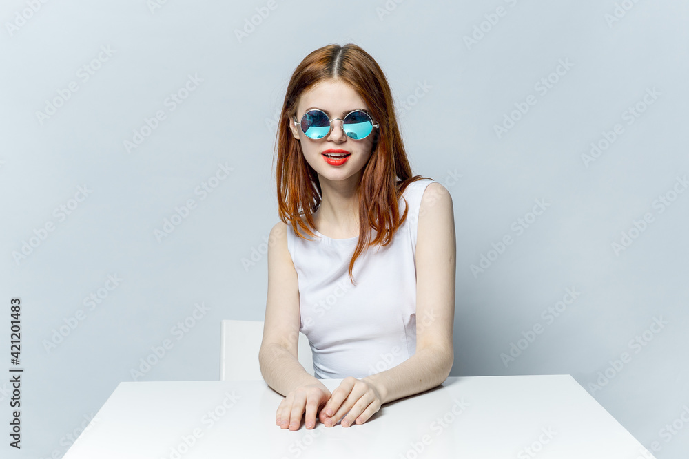 cheerful red-haired woman sitting at the table sunglasses cheerful red-haired woman sitting at the table sunglasses