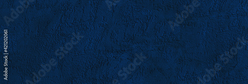 Toned concrete wall background. Decorative plaster texture. Dark blue abstract background with copy space for design. Web banner.